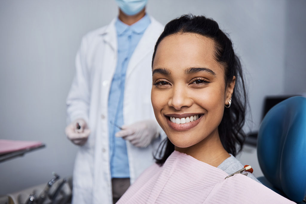 A young woman smiling at the camera during a dentist's visit